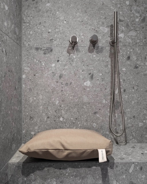 Nahaufnahme des Badesofa Sitzkissen (Farbe: Beige) auf einer gemauerten Bank in der Dusche. 